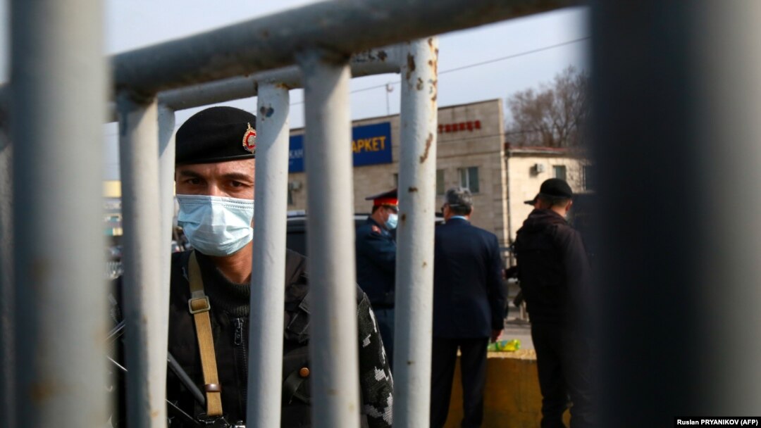A law enforcement officer at a checkpoint on the outskirts of Almaty on March 19, after authorities locked down the city to contain the spread of the coronavirus. 