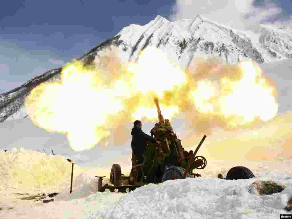 A member of an emergency services special unit fires a shell toward the upper slopes to clear snow buildup above the Transcaucasian highway some 110 kilometers from the southern Russian city of Vladikavkaz on March 13. Avalanches are a constant threat on the road, which is the only route connecting Russia to the Georgian separatist region of South Ossetia. Photo by Kazbek Basayev for Reuters