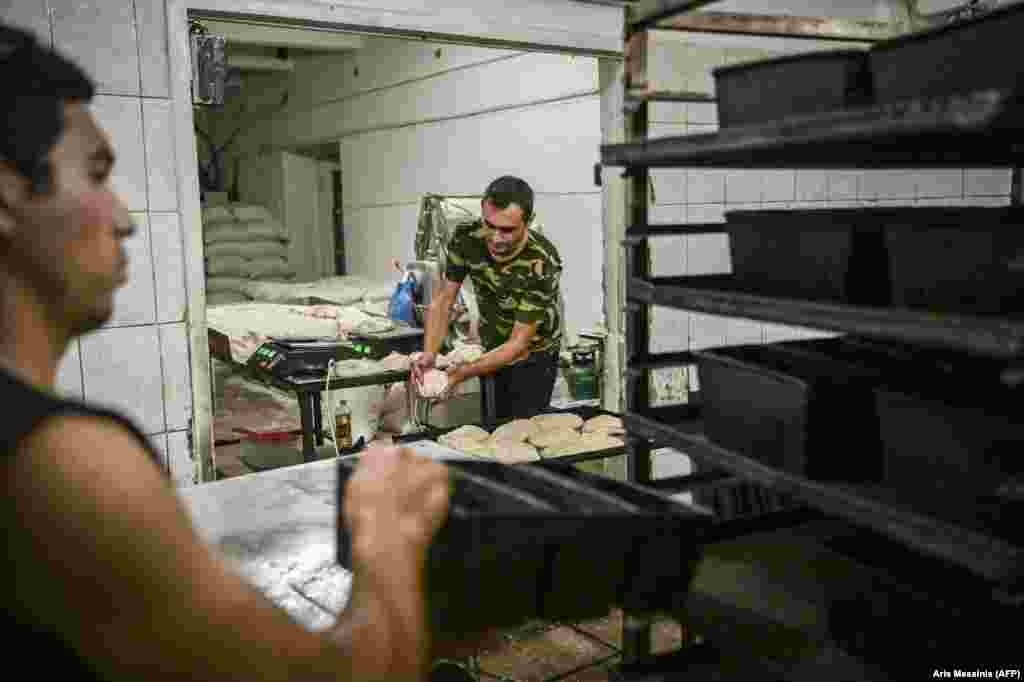 Workers prepare dough for the oven. &nbsp;