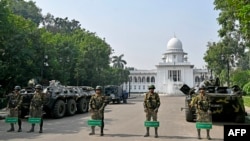 په ډاکې کې امنیتي سرتېري د نړیوالو جنایتونو جرګګۍ د ودانۍ مخې ته پهره ورکوي - د نومبر ۱۳مې انځور.