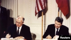 Президент США Рональд Рейган (П) та СРСР Михайло Горбачов (Л) підписують Договір про ліквідацію ракет середньої і малої дальності, 8 грудня 1987