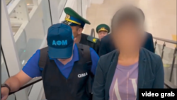 Скриншот из видео Агентства по финансовому мониторингу, демонстрирующий экстрадицию главы финансовой пирамиды The Finica