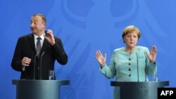 Azerbaijani President Ilham Aliyev (left) and German Chancellor Angela Merkel attend a press conference following their meeting at the Chancellery in Berlin on June 7.