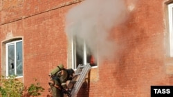 A firefighter stands on a ladder by a window of a garment factory on fire in the town of Yegoryevsk, southeast of Moscow, on September 11.