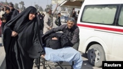 Iraq -- Residents wheel a stretcher carrying a wounded woman after a bomb attack targeted Shi'ite pilgrims commemorating the religious ceremony of Arbain, outside a hospital in Karbala, 24Jan2011