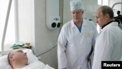 Russian Prime Minister Vladimir Putin (right) visits a victim of the Raspadskaya mine disaster at a hospital in Novokuznetsk today.