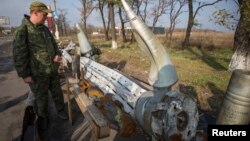 یکی از جدایی‌طلبان به بقایای مواد انفجاری که ساکنان شرق اوکراین می‌گویند نیروهای دولتی از آن‌ها استفاده کرده‌اند، نگاه می‌کند