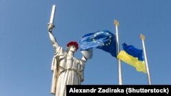 Ukraine and EU flags fly in front of the landmark Motherland statue in Kyiv. (file photo)