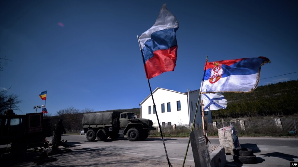 Zastava Rusije, Srbije i ruske mornarice (na fotografiji, 13. mart 2014.) dok ruski vojni kamion prolazi kontrolni punkt na putu od Simferopolja prema Sevastopolju na poluostrvu Krim koji je anektovala Rusija 2014. godine.