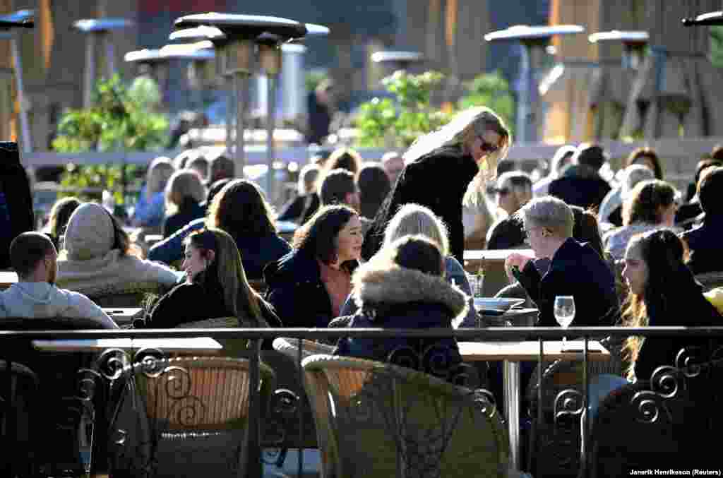 Suedezët shijojnë rrezet e diellit të pranverës në një restorant në natyrë në Stokholm, më 26 mars.