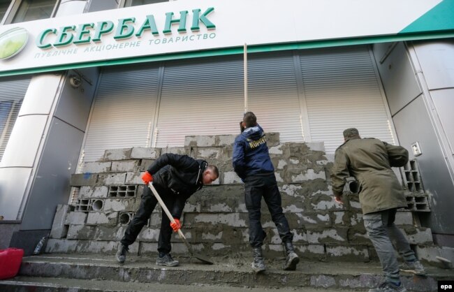 Активисты "Национального корпуса" заканчивают строительство стены у входа в Сбербанк