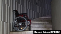 Коляска для инвалидов стоит на лестнице во Дворце школьников. Астана, 18 ноября 2015 года.