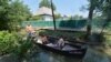 A family travels by boat down one of the main thoroughfares of Vylkove.