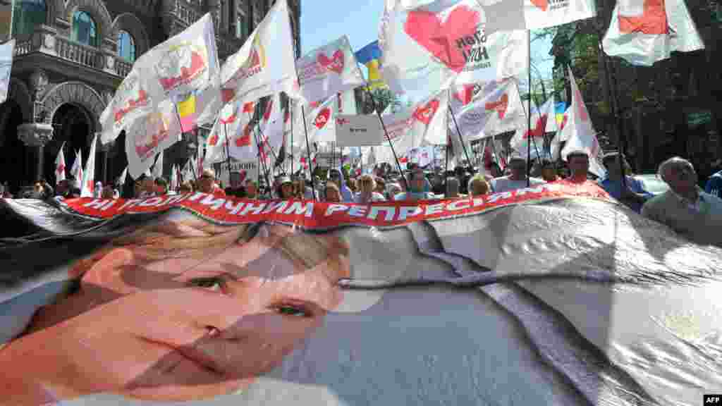 Tymoshenko supporters carry a huge poster featuring her during a rally of the opposition in Kyiv on April 27, 2012.