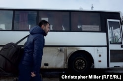 A man passes a bus traveling to the Russian city of Belgorod at the Hoptivka border crossing on November 29.