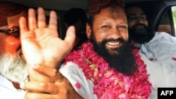 Lashkar-e Jhangvi leader Malik Ishaq waves to supporters in Lahore on July 14.