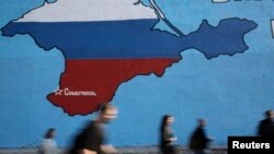Russia -- People pass a mural showing a map of Crimea in the Russian national colours on a street in Moscow, March 25, 2014. Russia's annexation of Crimea has piqued interest in the region's Tatar community.