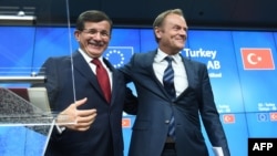 Turkish Prime Minister Ahmet Davutoglu (left) smiles with European Council president Donald Tusk during a press conference at the end of a summit on relations between the European Union and Turkey and on the migrant crisis at the European Council in Brussels.