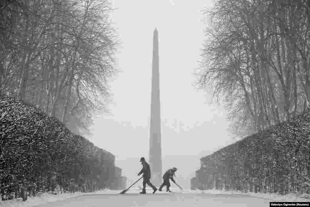 Workers remove snow during a heavy snowfall in Kyiv on December 18. (Reuters/Valentyn Ogirenko)