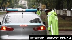 Полицейский рядом со служебным автомобилем.