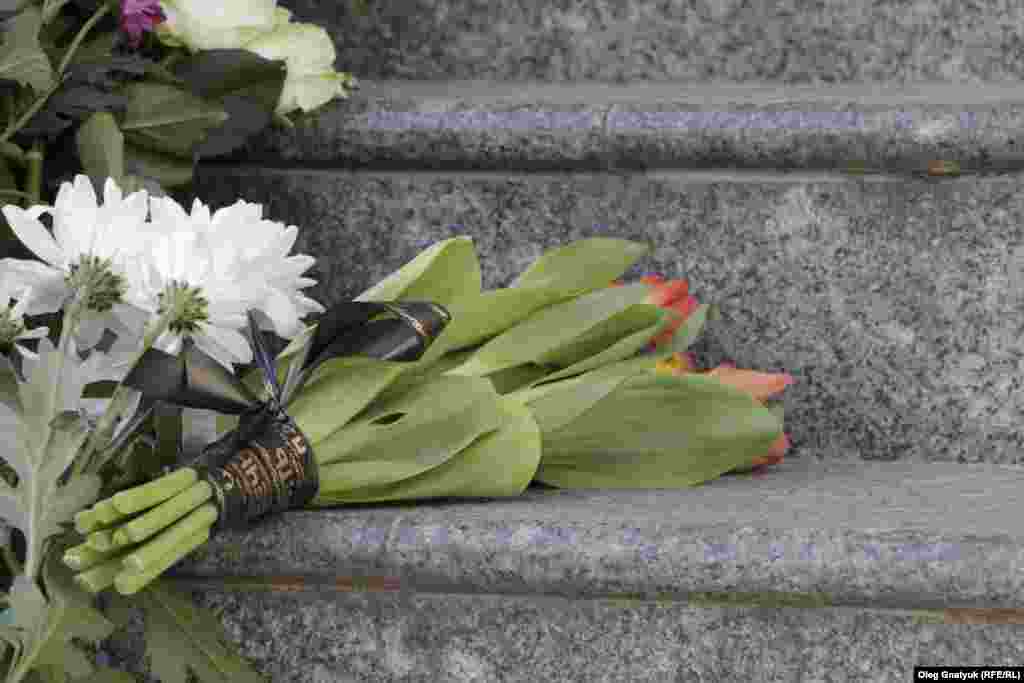 Букети квітів перев&#39;язані траурними стрічками
