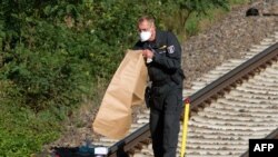 Полицейские убирает очередную обнаруженную бомбу с железнодорожных путей