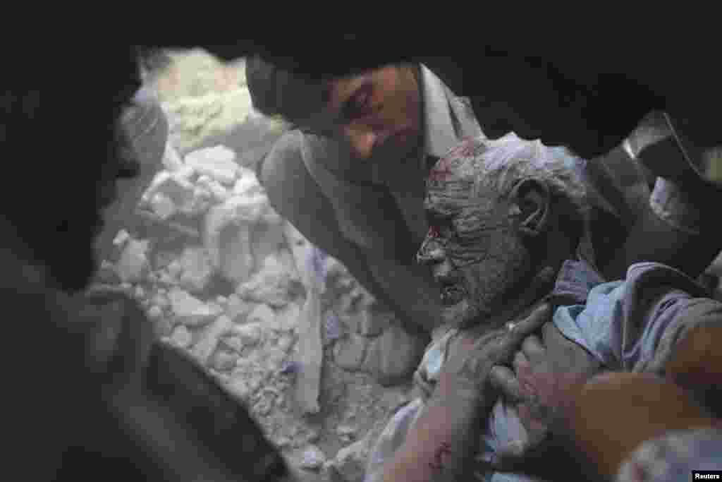 Un bărbat rănit este scos din ruinele unei clădiri lovite de bombardamentele armatei siriene la Douma, lîngă Damasc. (Reuter/Bassam Khabieh)