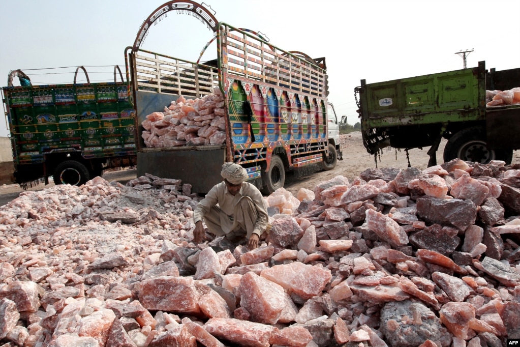 Một công nhân thu gom đá muối để xếp lên xe tải bên ngoài mỏ muối Khewra. & Nbsp;