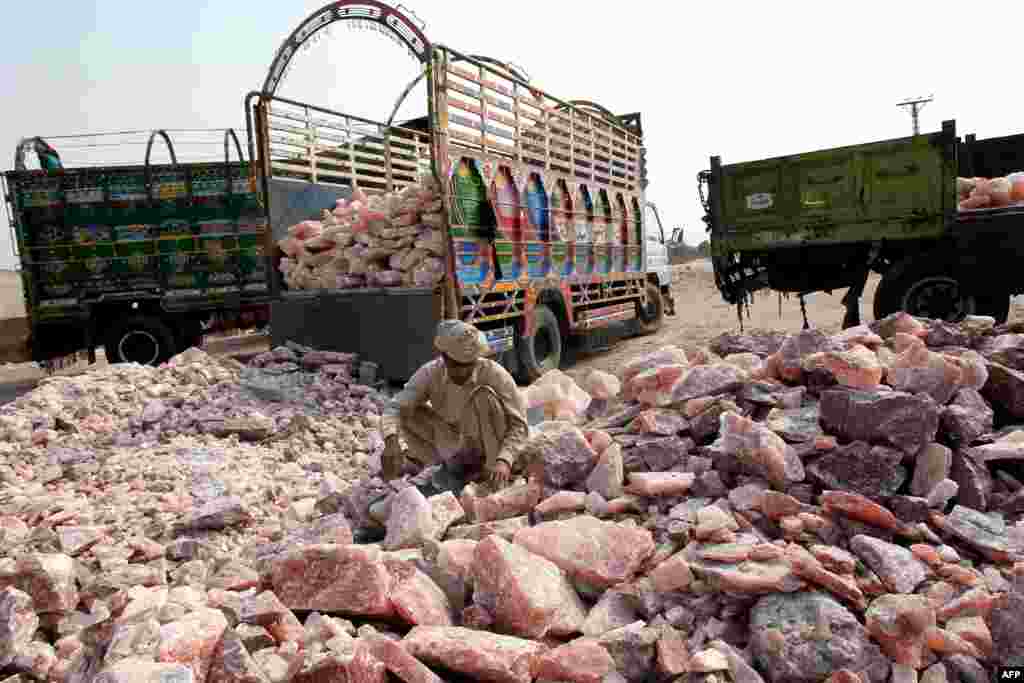 A worker collects salt stones for loading onto a truck outside the Khewra salt mines.&nbsp;