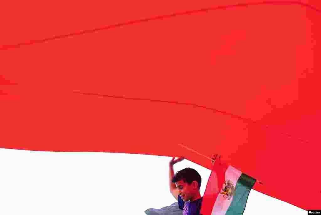 A boy walks under a flag of Iran used before the Islamic Revolution during the Persian Day Parade to celebrate the Iranian New Year in New York on April 15. (Reuters/Keith Bedford)