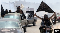 Syria -- Fighters from Al-Qaeda's Syrian affiliate Al-Nusra Front drive in the northern Syrian city of Aleppo flying Islamist flags as they head to a frontline, May 26, 2015