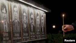 A man lights a candle at a memorial dedicated to firefighters and workers who died after the Chernobyl nuclear disaster, during a night service in the city of Slavutych on April 25.