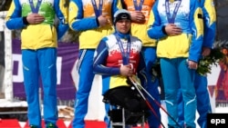 Ukrainian silver medalist Olena Iurkovska (front) and teammates cover their medals during the medal ceremony after the Cross Country 4 x 2.5-Kilometer Mixed Relay competition at Laura Cross-Country Ski & Biathlon Center during the Sochi Paralympic Games in a show of protest against events in their homeland, where Russian troops are occupying Crimea.