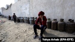 Yemenis wait next to empty cooking-gas cylinders for gas supplies amid increasing gas shortages in the capital, Sanaa, last month. 