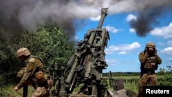 Украинские военные наносят артиллерийские удары из американской гаубицы M777 по скоплению российской техники вблизи линии фронта в Донецкой области, 6 июня 2022 года.