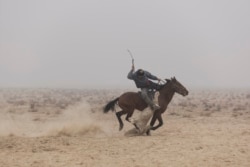 Всадник скачет с муляжом туши козла во время конноспортивной игры бузкаши. Окрестности Бухары, 2019 год.