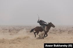 Всадник скачет с муляжом туши козла во время конноспортивной игры бузкаши. Окрестности Бухары, 2019 год.