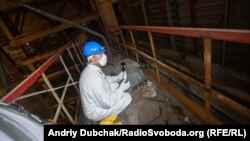 Кореспондент Радіо Свобода Євген Солонина сидить поруч з елементром конструкцій 4-го реактора, який викинуло сюди під час вибуху у 1986-му році