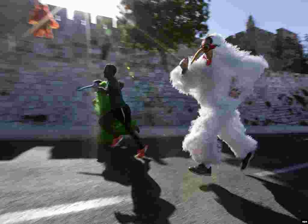 Israeli street performers run along next to a marathon contestant as they pass the Old City walls and the Tower of David complex during the fourth annual Jerusalem Marathon. (AFP/Jim Hollander)