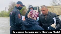 Politsiya hadimleri ve Rustem Emirusenovnıñ anası (Foto: Qırım birdemligi)