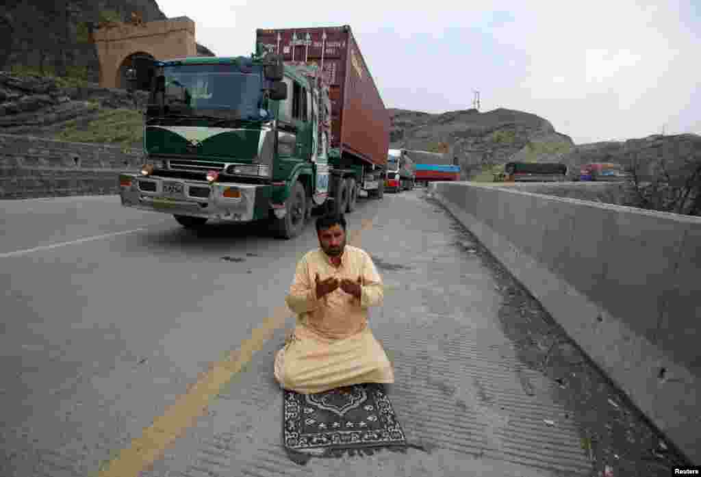 A truck driver offers afternoon prayers near his supply truck after the opening of the Torkham border crossing to Afghanistan in Landi Kotal, Pakistan. Pakistan ordered the two main border crossings with Afghanistan to be reopened on March 20, calling it a &quot;goodwill gesture.&quot; The border closures on February 16 had left hundreds of thousands of people stranded at the two major crossings of Torkham and Chaman. (Reuters/Fayaz Aziz)