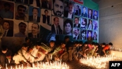 FILE: Residents place candles at the site during a vigil to pay tribute to victims a day after a suicide bombing at the Civil Hospital in Quetta.