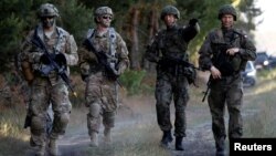 Polish 6th Airborne Brigade soldiers (right) walk with U.S. 82nd Airborne Division soldiers during the NATO allies' Anakonda-16 exercise near Torun, Poland on June 7.