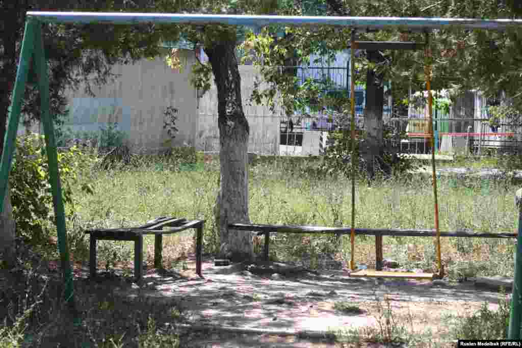 Дворы домов, построенных в 1980-е годы, заросли травой, на территории остались сломанные старые качели и скамейки. Алматы, 21 августа 2013 года.