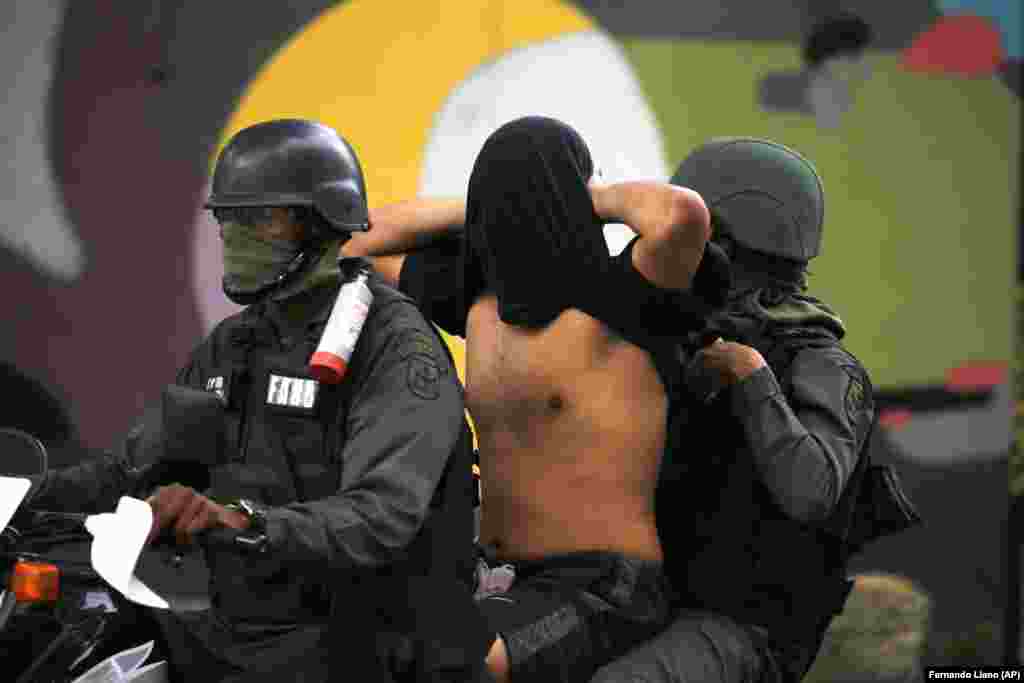 Troops detain an antiovernment protester.