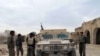 Members of the Afghan security forces stand around a lightly armored vehicle during an operation against Taliban fighters in Helmand, December 2015.