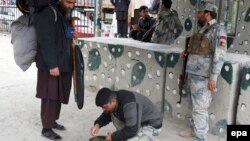 Afghan security officials check a man at Torkham border crossing in March following a previous closure.