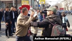 Азаттықтың түсірілім тобының камерасын газетпен жауып, журналистер жұмысына кедергі келтіріп тұрған белгісіз адам. Алматы, 22 наурыз 2019 жыл.