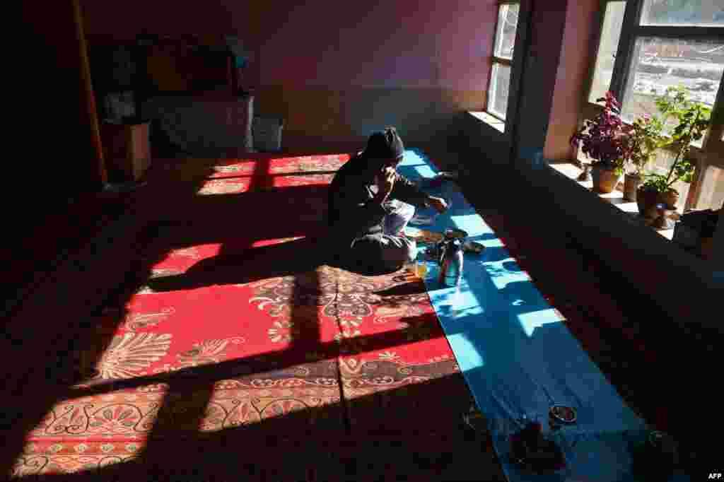 A Hazara man talks on his phone during a meal at a restaurant.