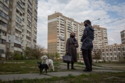Жінки вигулюють собак між будинками вулиці Радунської